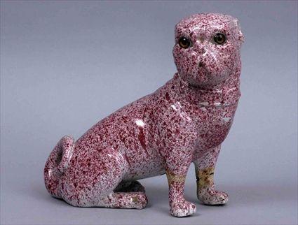 Appraisal: PINK SPONGED FAIENCE FIGURE OF A SEATED DOG Head turned