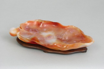 Appraisal: A Carved Orange Agate Lily Pad The image of a