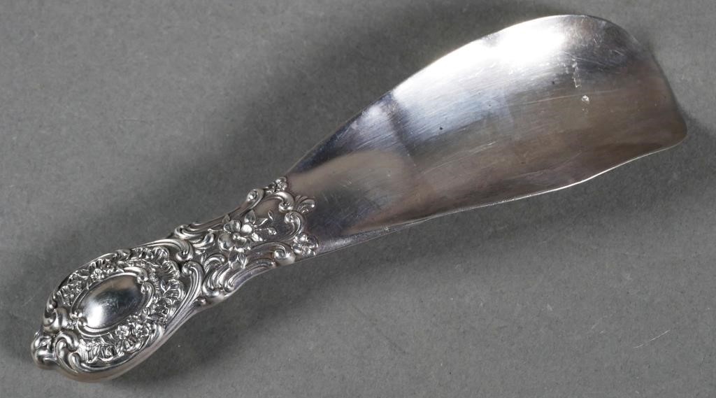 Appraisal: Sterling silver shoe horn with decorative relief design on handle