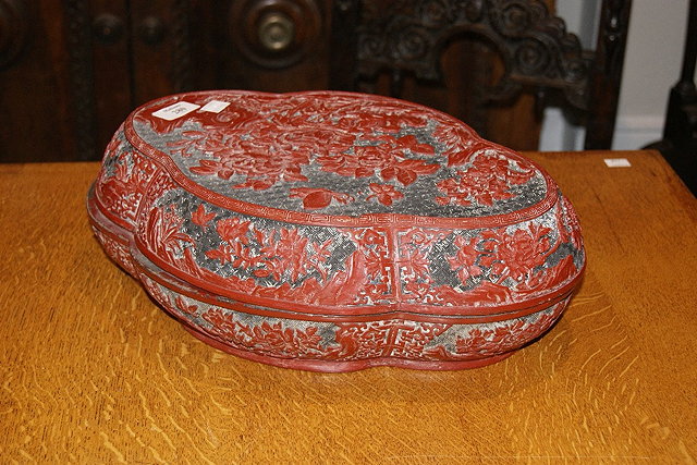 Appraisal: Chinese cinnabar red lacquer oval boxthe cover with peonies and