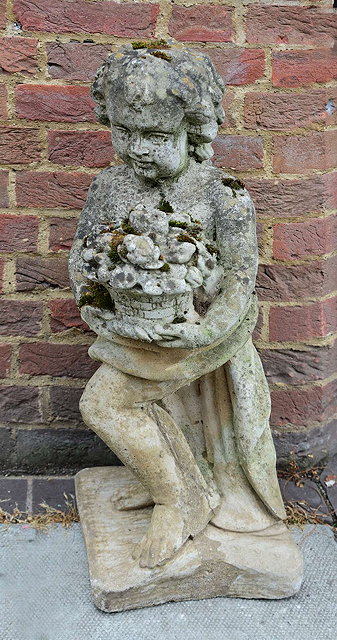 Appraisal: AN OLD WEATHERED GARDEN COMPOSITE STONE STATUE of a cherub