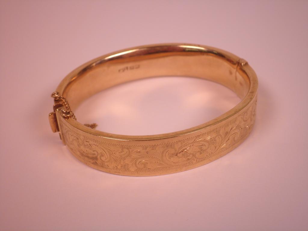 Appraisal: A carat gold bangle engraved with foliate scrolls