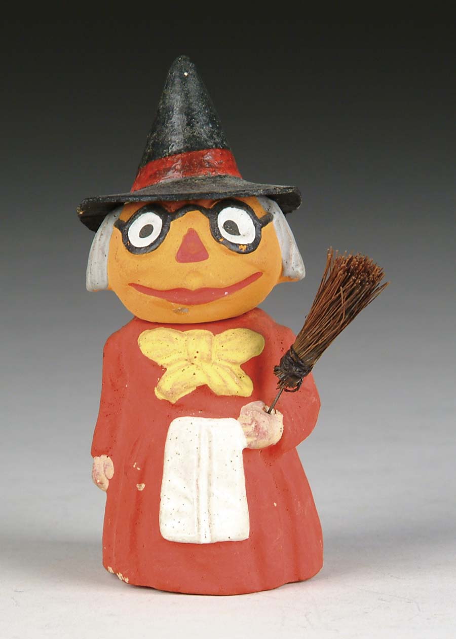 Appraisal: PUMPKIN-HEAD WITCH FIGURAL CANDY CONTAINER All composition red-dressed witch holding