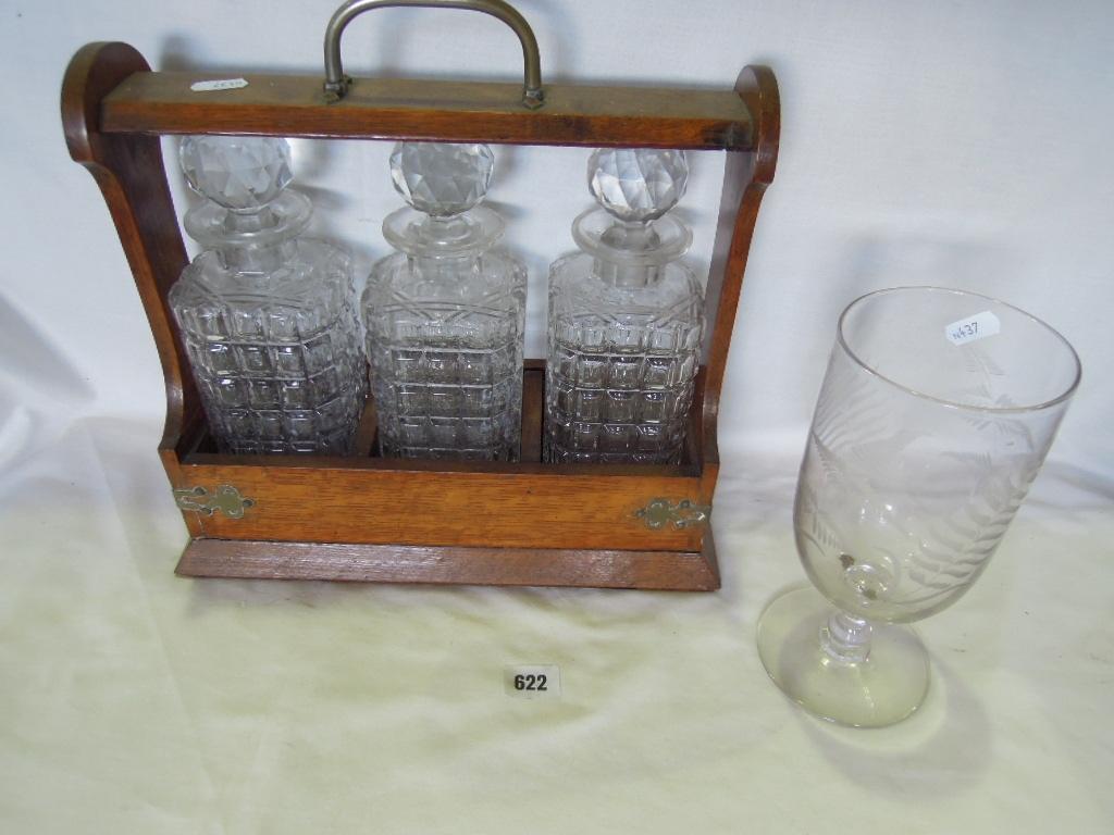 Appraisal: An oak tantalus fitted with three square cut decanters and