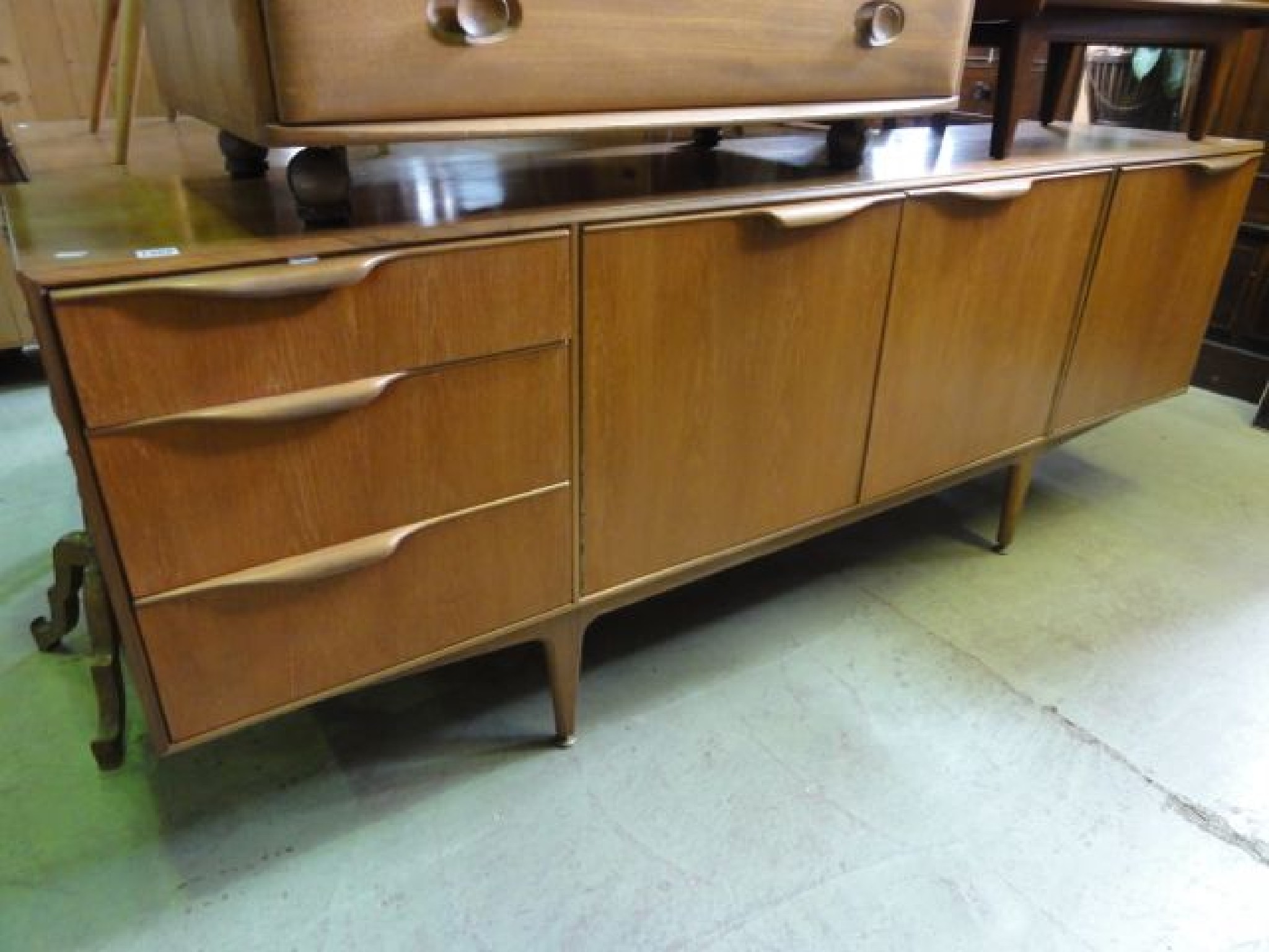 Appraisal: A McIntosh teak dining room suite comprising long low sideboard