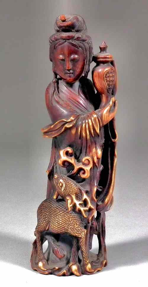 Appraisal: A Chinese stained ivory figure of Guanyin holding a vase