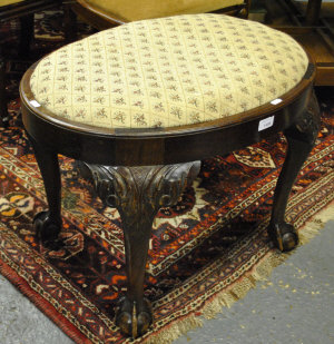 Appraisal: An oval mahogany dressing stool with drop-in padded seats on