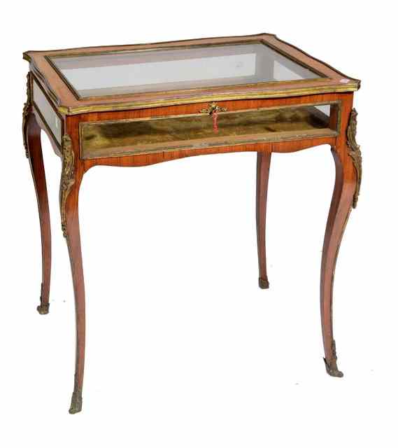 Appraisal: A FRENCH KINGWOOD SERPENTINE BIJOUTERIE TABLE with glazed top and