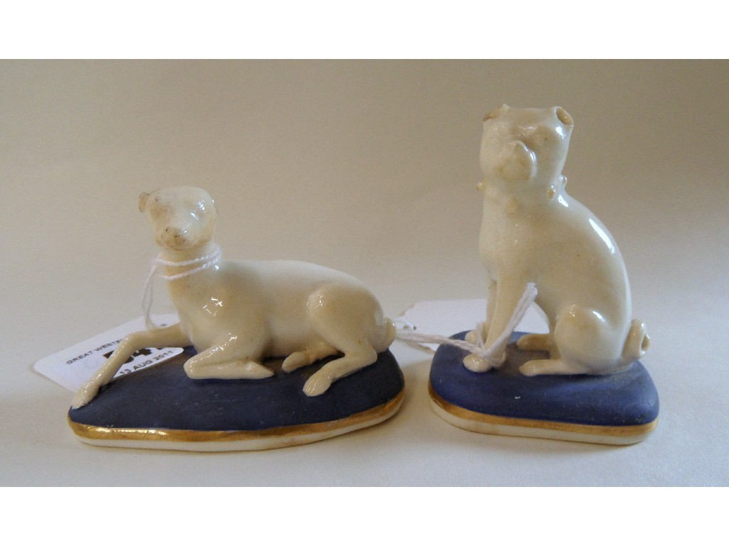 Appraisal: Two small Staffordshire figures of dogs seated on blue cushions