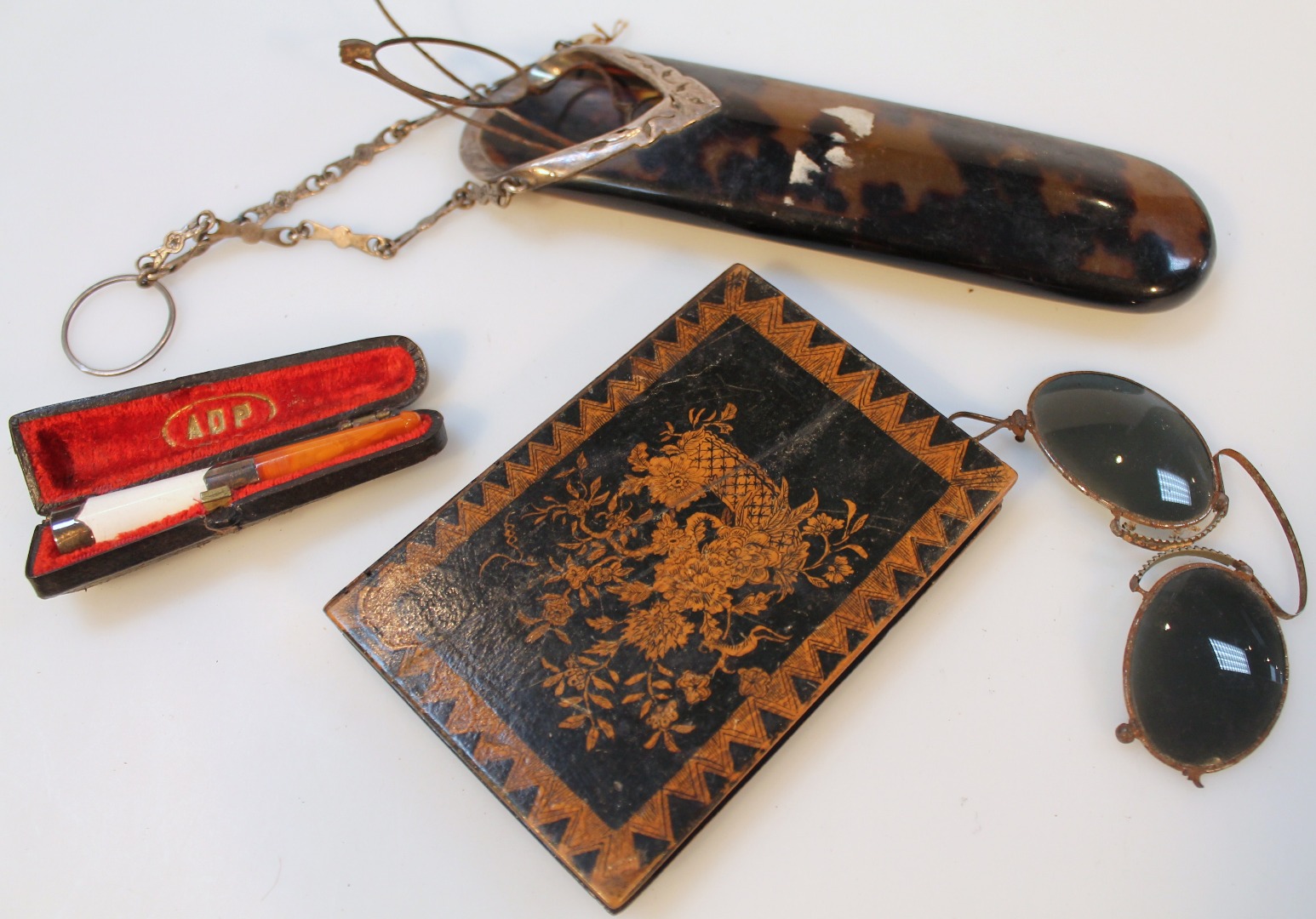 Appraisal: An Edwardian tortoiseshell and silver spectacles case with chain loop