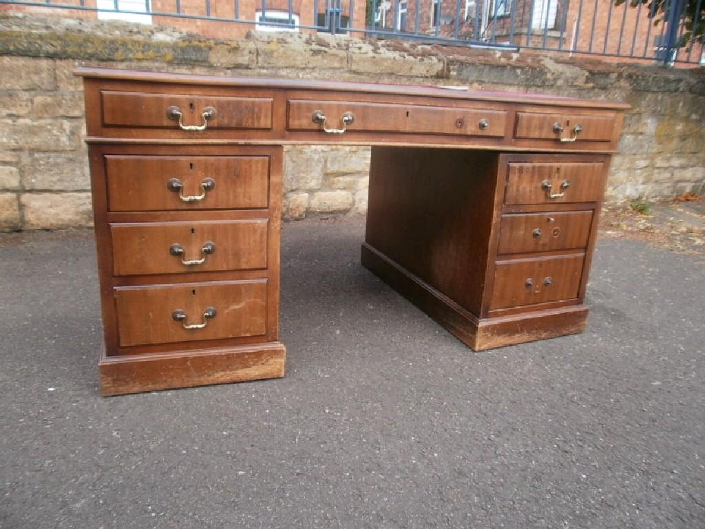 Appraisal: A mahogany pedestal desk rectangular top with a red leatherette