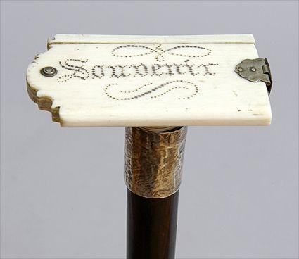 Appraisal: IVORY-HANDLED EBONIZED WOOD WALKING STICK Fitted with a souvenir book