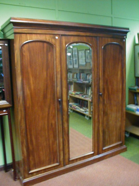 Appraisal: A Victorian mahogany triple wardrobe with mirrored centre door