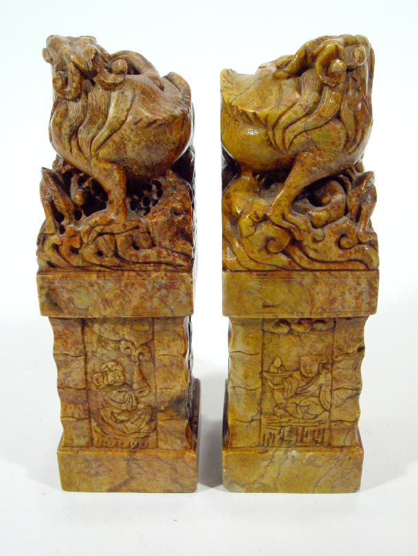 Appraisal: Two oriental carved stone columns decorated with dog of Foo