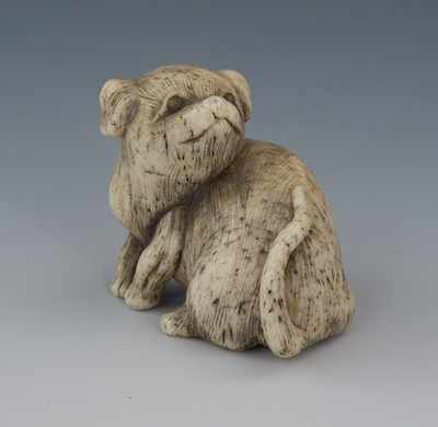 Appraisal: A Carved Bone Netsuke of a Dog Cute seated dog