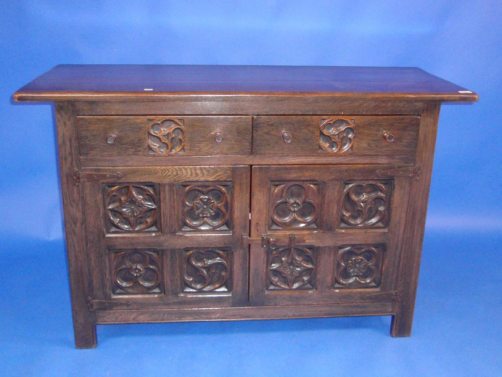 Appraisal: A carved oak sideboard with two drawers over two doors