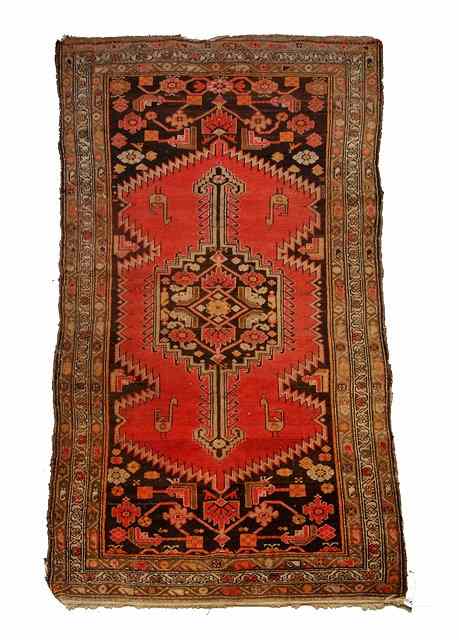 Appraisal: A HAMADAN RED GROUND RUG with a central stylised medallion