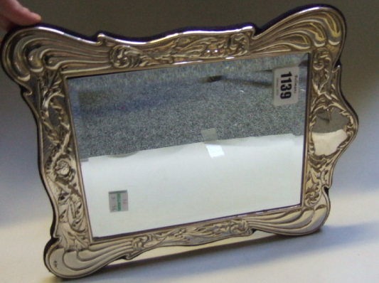 Appraisal: A silver mounted rectangular strut backed mirror with a shaped