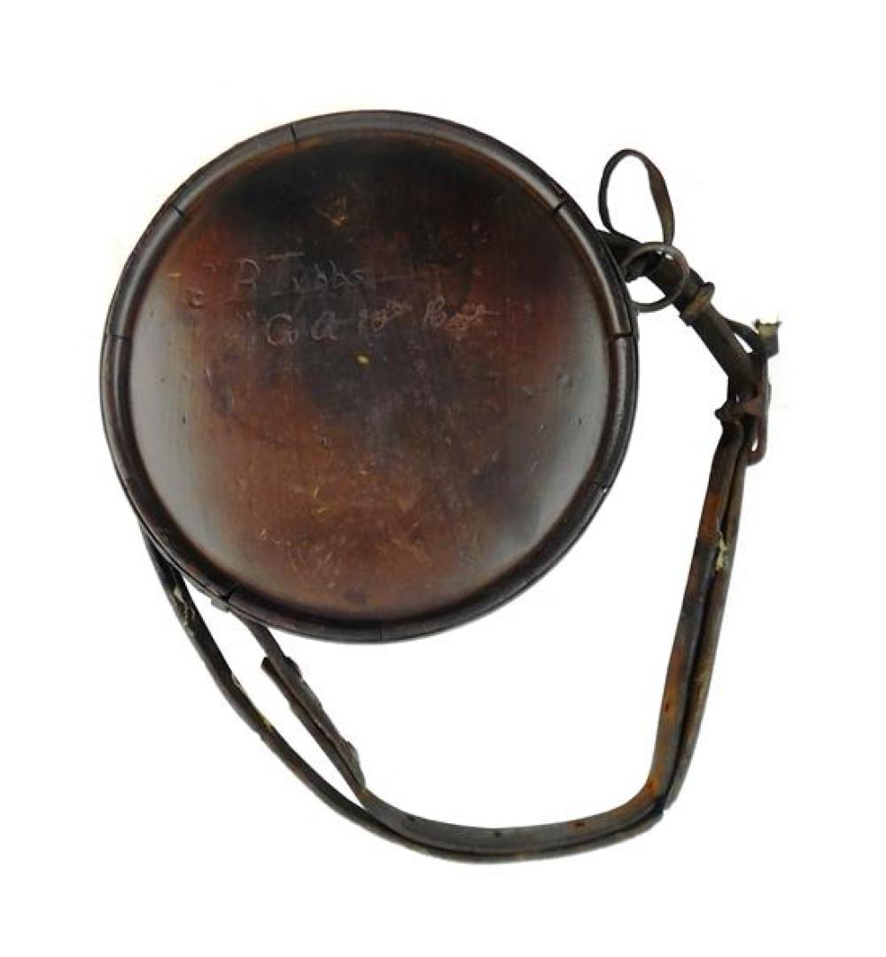 Appraisal: Wooden round canteen Civil War era leather strap hand carved