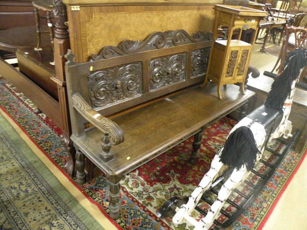 Appraisal: A Victorian carved oak settle the panelled back carved with