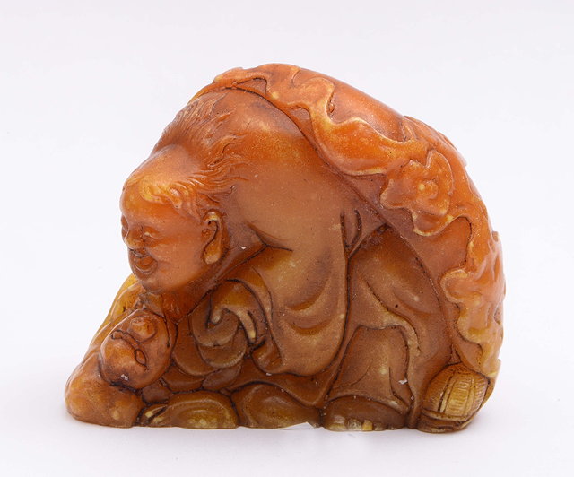 Appraisal: A Chinese mottled cream and brown soapstone pebble th Centurycarved