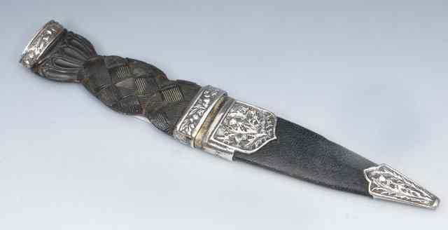 Appraisal: A SCOTTISH SGIAN DUBH with composite handle silver mounts decorated