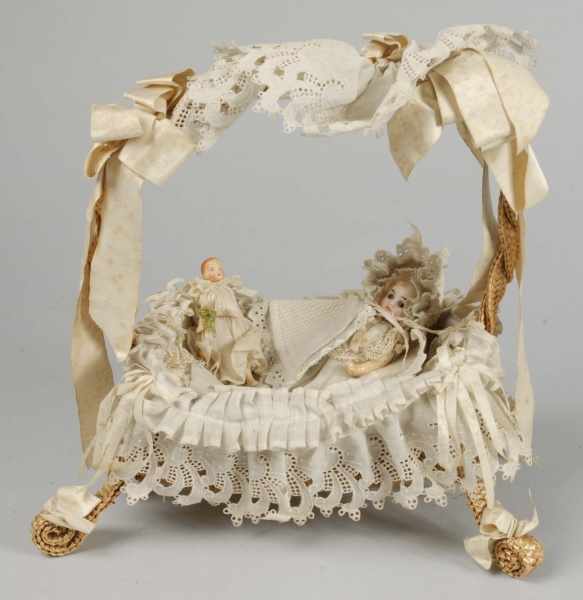 Appraisal: Wicker Basket Cradle with Dolls Description Bisque socket head child