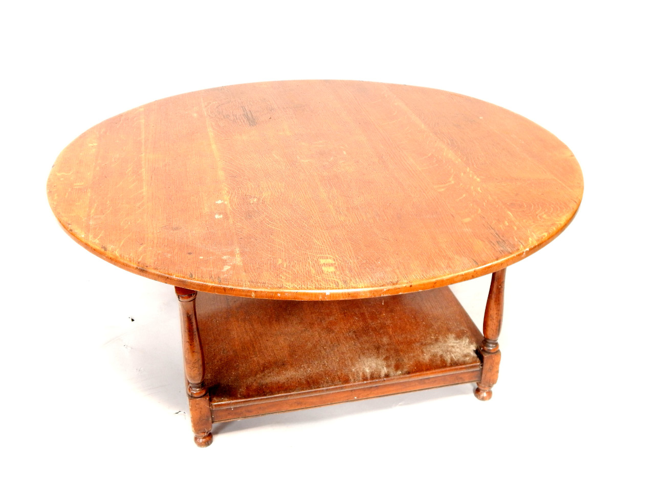 Appraisal: A circular oak coffee table upon turned legs and rectangular