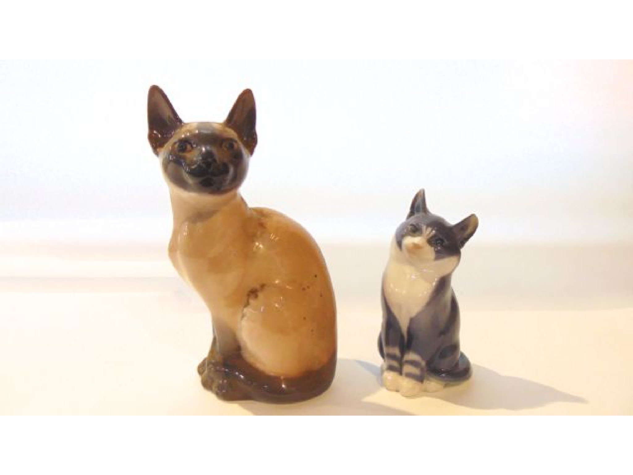 Appraisal: Two Royal Copenhagen models of seated cats one a Siamese