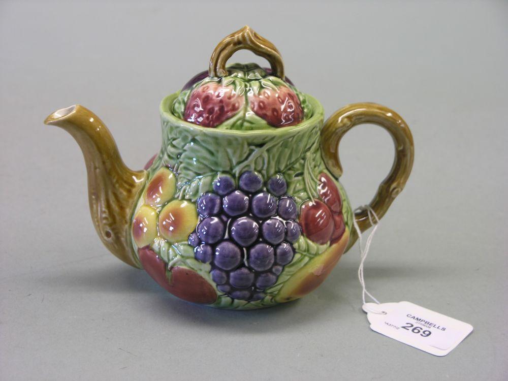 Appraisal: A Sarreguemines teapot boldly moulded with fruit and brightly glazed