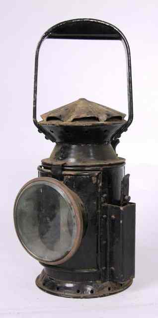 Appraisal: A twin glass ebonised railway lamp with Sherwood porcelain burner