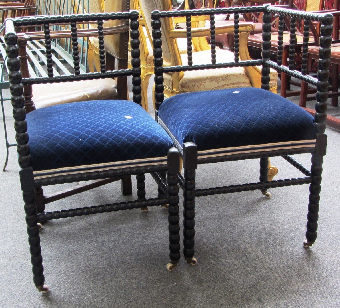 Appraisal: A pair of th century ebonised bobbin turned corner chairs