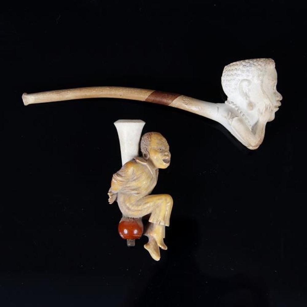 Appraisal: TWO MEERSCHAUM AFRICAN FIGURAL PIPES SEATED MAN WITH HANDS CUFFED