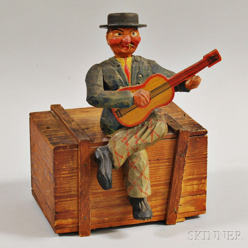 Appraisal: Figural-carved Music Box America th century the musician with guitar