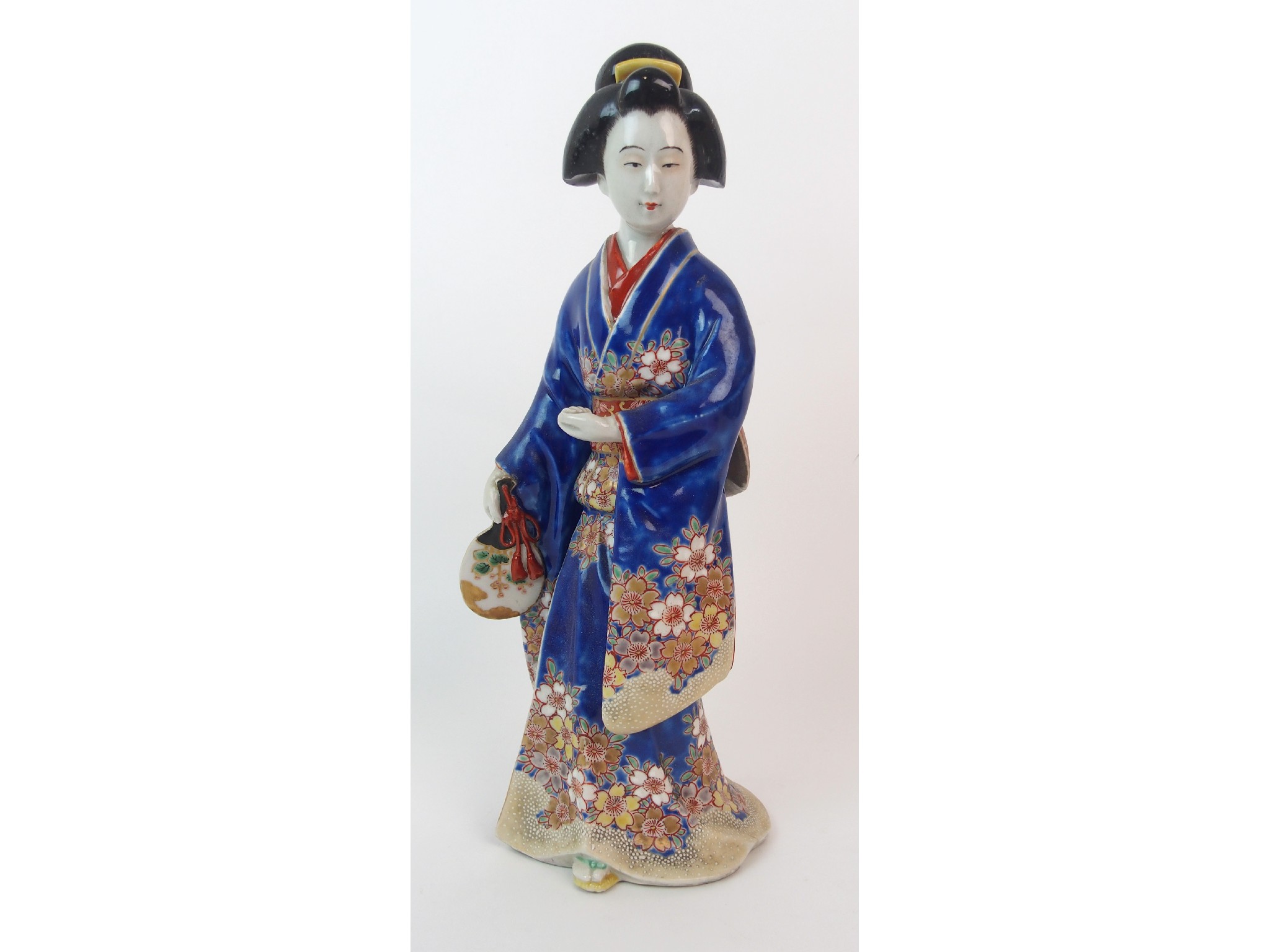 Appraisal: An Arita figure of a ladystanding holding a fan and