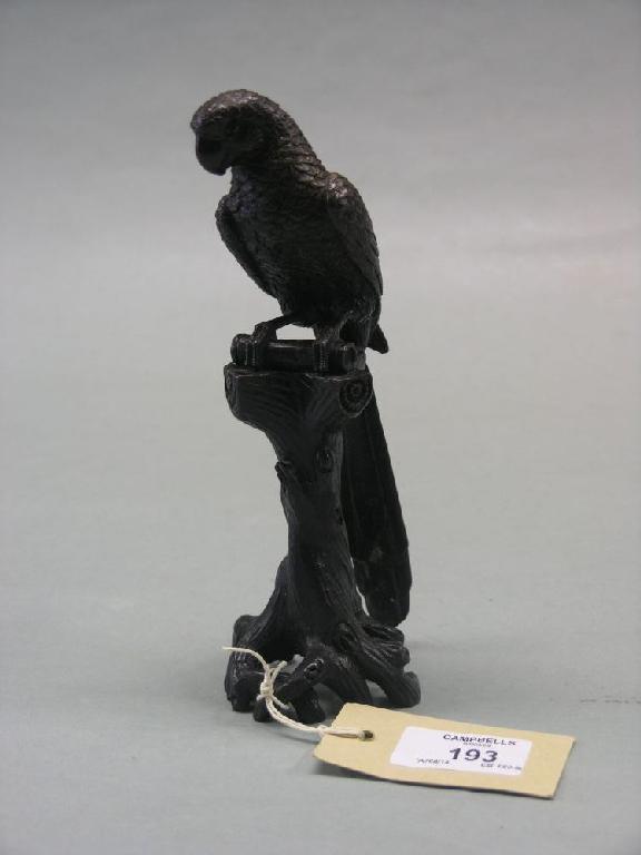 Appraisal: A bronze parrot model perched upon tree stump in