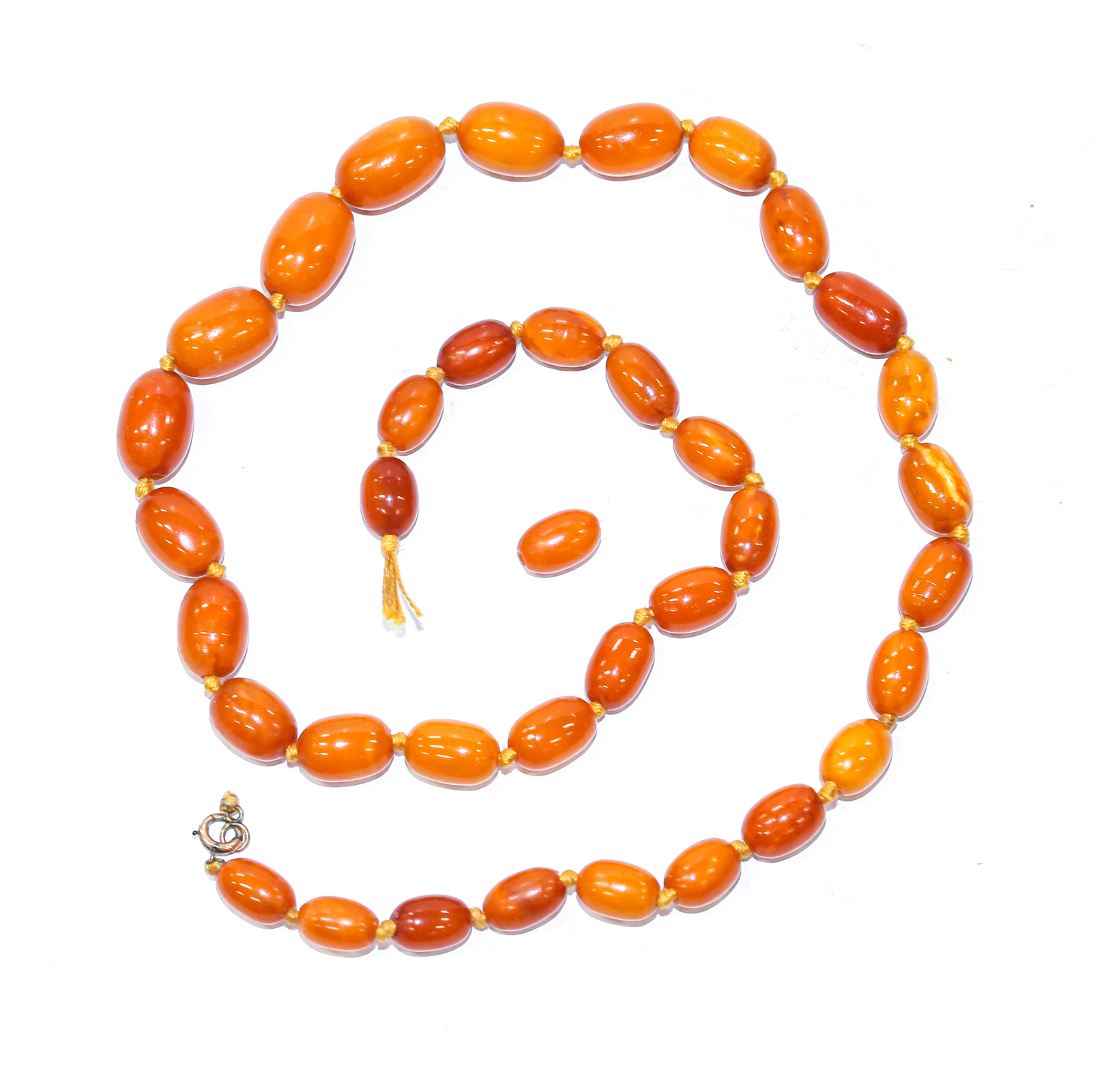 Appraisal: AN AMBER BEADED NECKLACE Amber beaded necklace oval beads slight