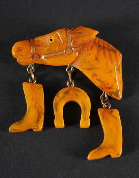 Appraisal: Bakelite Horse Head Pin Description With dangling boots and horseshoe