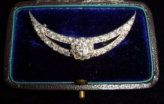 Appraisal: A crescent shaped diamond brooch set a central diamond within