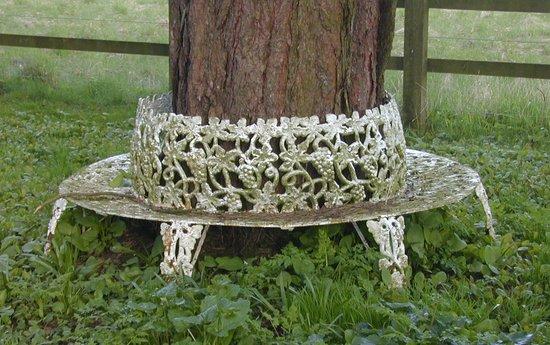 Appraisal: A cast iron circular tree seat pierced grapes and vines