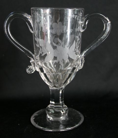 Appraisal: A moulded glass loving cup etched with floral sprays and