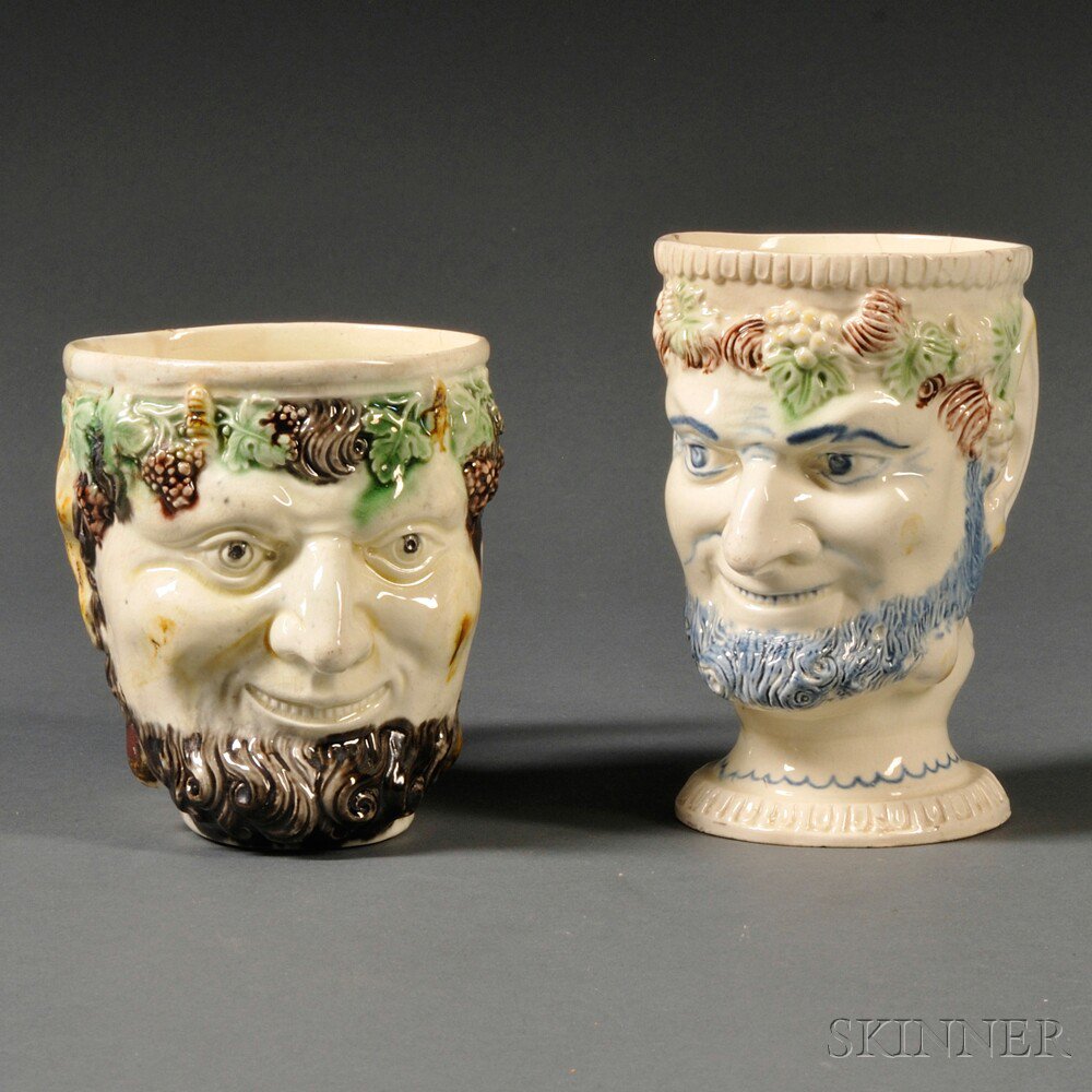 Appraisal: Two Staffordshire Cream-colored Eatrhenware Bacchus-face Mugs England late th century