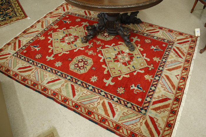 Appraisal: HAND KNOTTED ORIENTAL CARPET Indo-Kazak tribal featuring twin geometric medallions