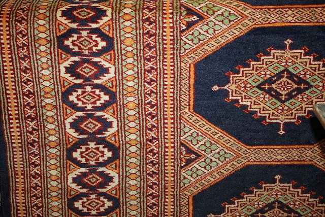 Appraisal: A PAKISTAN CREAM GROUND WOOL RUG with central stylised medallions