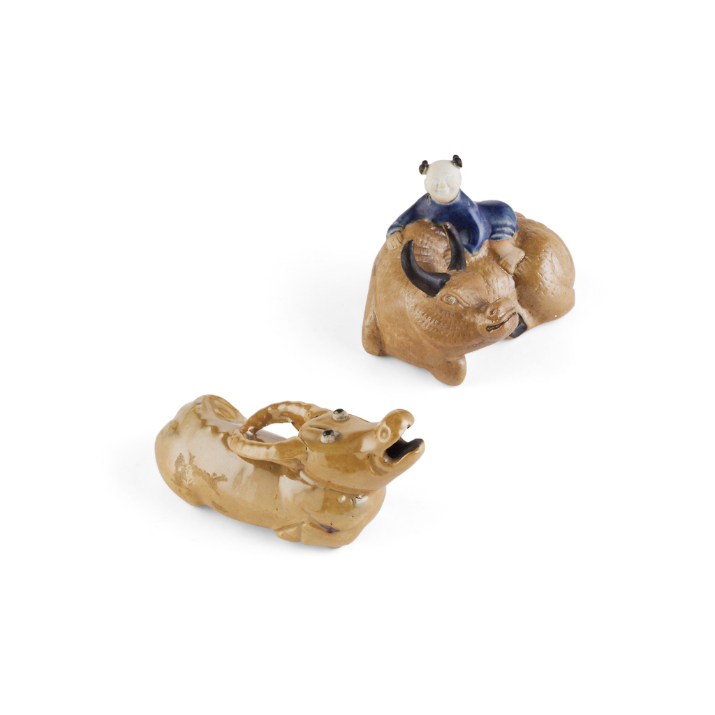 Appraisal: TWO BISCUIT-GLAZED BUFFALO FIGURES one moulded with a boy resting