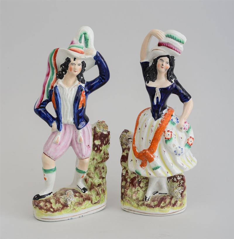 Appraisal: PAIR OF STAFFORDSHIRE POTTERY FIGURES OF A YOUTH AND A