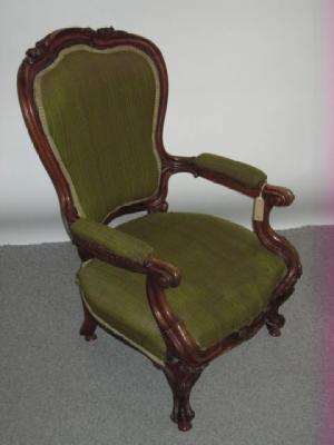 Appraisal: A VICTORIAN CARVED WALNUT FRAMED ELBOW CHAIR upholstered in a