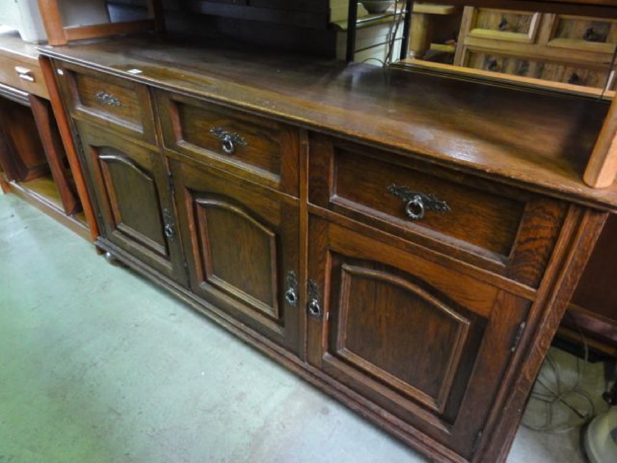 Appraisal: A reproduction oak dresser base enclosed by three arched moulded