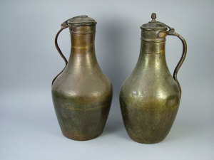 Appraisal: Two North African copper ewers with hinged lids and curved