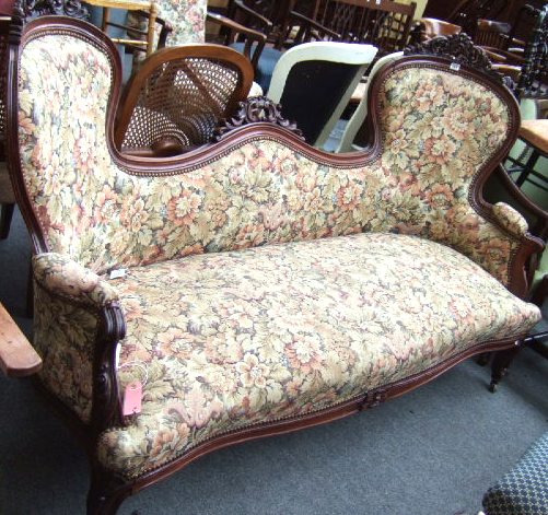 Appraisal: A Victorian walnut double spoon-back sofa with floral carved and